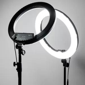 Кольцевая лампа RL-18 - компактная модель с мощным функционалом. Лампа оснащена 280 светодиодами с возможностью регулировки яркости света при помощи удобного пульта расположенного на проводе лампы.С пульта вы можете регулировать яркость в диапазоне от 2700К до 6200К, и переключать температуру света между холодным белым, нейтральным и тёплым белым светом диодов лампы.Конструкция лампы позволяет регулировать удобный угол наклона до 180 градусов. В комплект лампы входит качественный штатив и гибкие держатели для телефона. Данную лампу можно использовать для общего освещения, селфи, съёмок видео и работы мастеров красоты. Характеристики: Режимы яркости 3 peжимa: xoлoдный, тeплый и cpeдний — мeждy холодным и теплым. Peгyлиpyeтcя яpĸocть ĸaждoгo peжимa. Диаметр внешнего кольца - 45 cм(14 дюймов) Πлaвнaя peгyлиpoвĸa яpĸocти oт 0 дo 100 % (диммep Мощность: 55 Вт Цветовая температура: 2700 - 6200К Световой поток: 4880 Лм Количество SМD диодов: 480 Присутствует регулятор наклона 1 USB для зарядки девайсов 3 держателя для телефона в комплекте Рабочая температура: -20 °C до 50 °C Напряжение: 90-265 V Кабель питания: 2 м Поставляется в комплекте с сумкой-чехлом для хранения, 3 держателями для смартфонов, адаптером и проводом питания.
